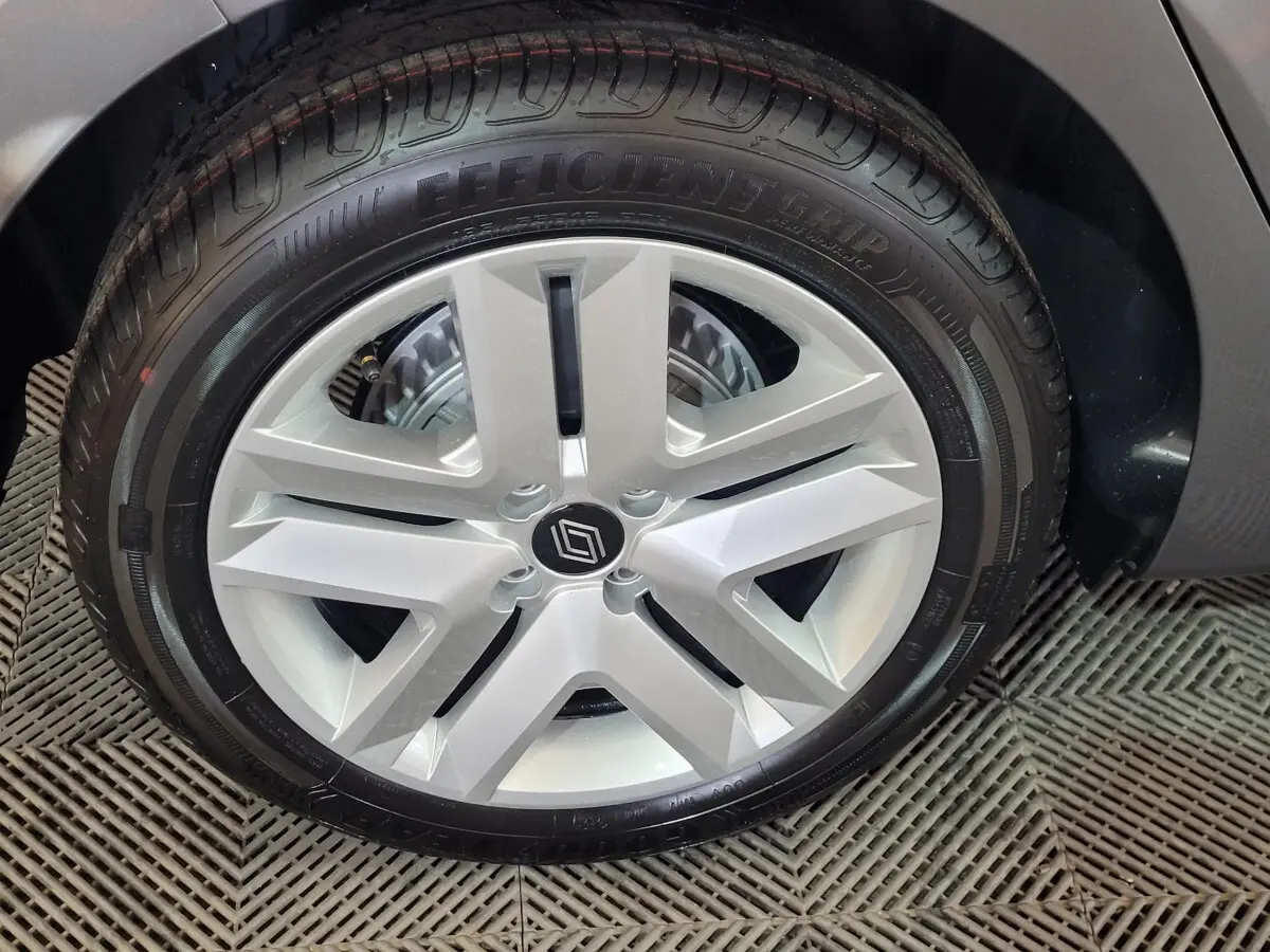 Gros plan sur la roue arrière droite d'une Renault Clio gris foncé, mettant en valeur le pneu et l'aile du véhicule.