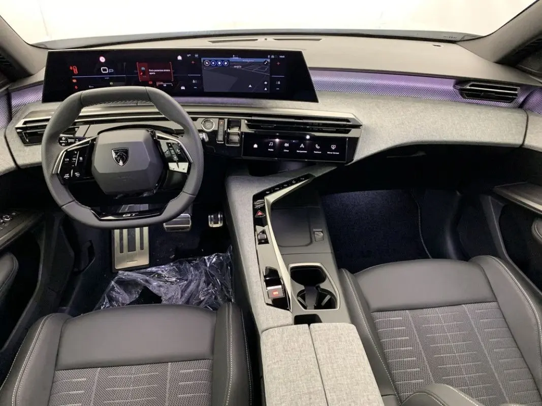 Vue intérieure rapprochée des sièges avant gris et noir du Peugeot 3008 Hybrid 2026 avec console centrale et volant partiel.
