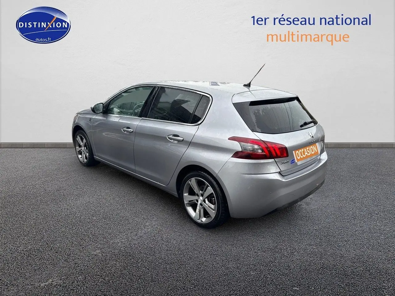 Vue 3/4 arrière droit d'une Peugeot 308 gris Artense 5 portes, avec jantes alliage et feux arrière LED distinctifs.