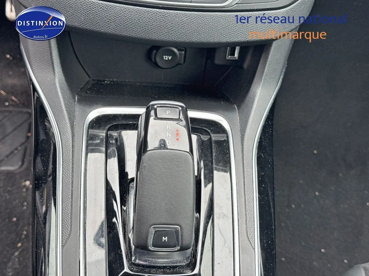 Le levier de vitesses automatique noir de la Peugeot 308 gris Artense vu de dessus, avec prise 12V et port USB à l'arrière.