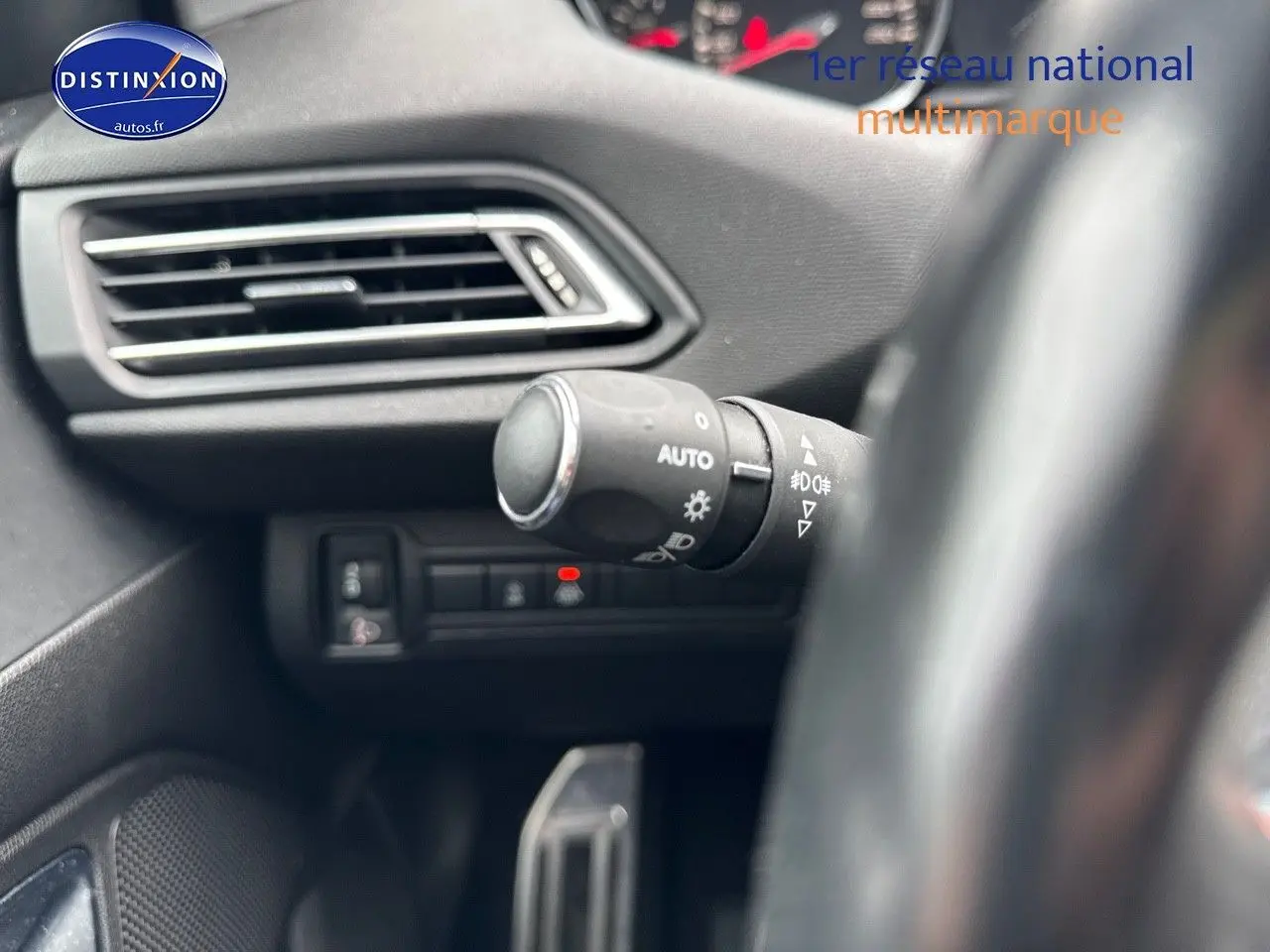 Gros plan sur la commande d'éclairage à gauche du volant dans l'habitacle d'une Peugeot 308 gris Artense 2019.