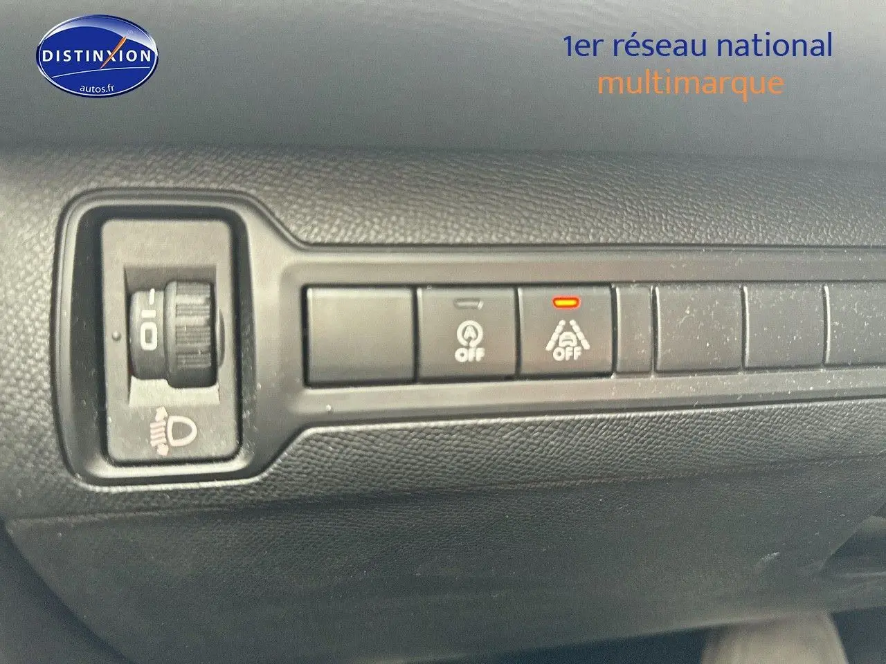 Gros plan sur les commandes de réglage des phares et d'assistance à la conduite dans l'habitacle d'une Peugeot 308 gris Artense.