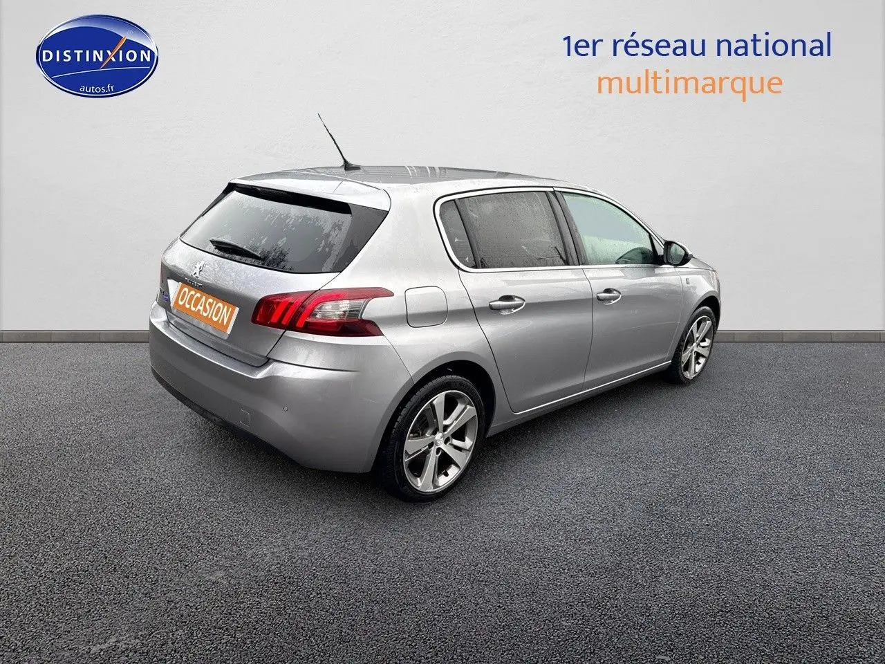 Peugeot 308 gris Artense vue 3/4 arrière droit, compacte cinq portes avec jantes alliage et feux LED distinctifs.