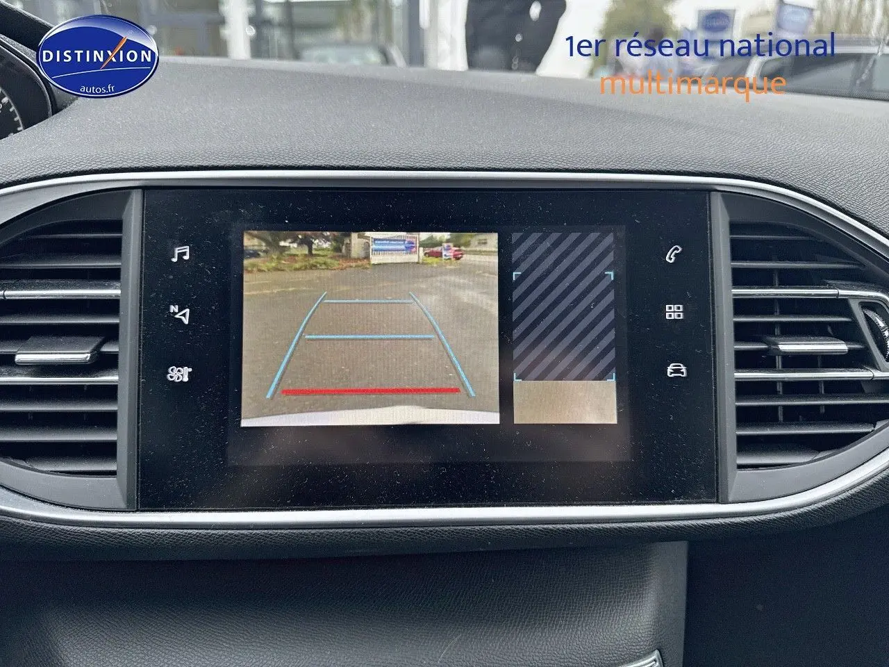 Écran central de la Peugeot 308 gris Artense de 2019 montrant la caméra de recul avec lignes de guidage bleues et rouges.