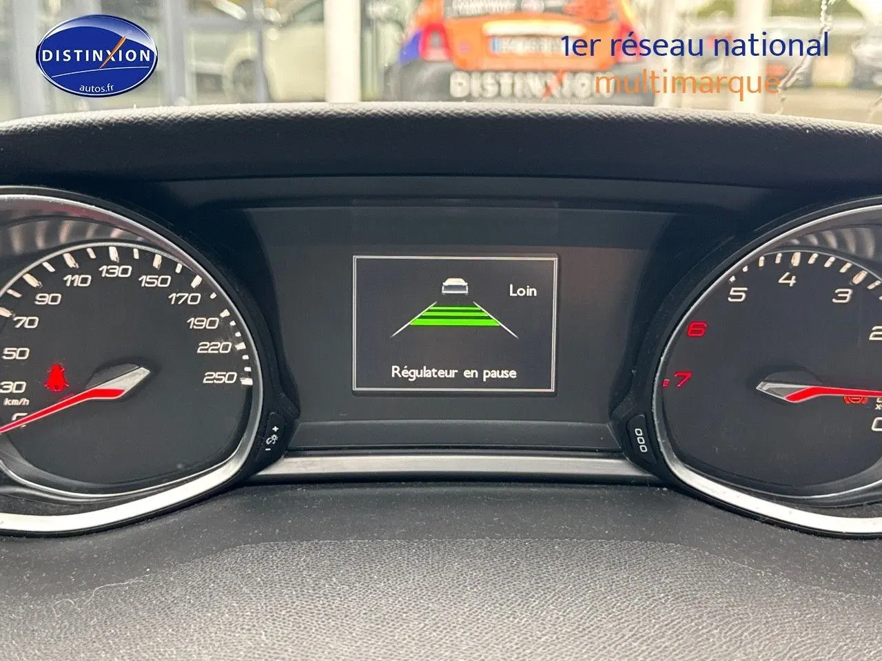 Tableau de bord de Peugeot 308 gris Artense, affichant le régulateur de vitesse en pause sur écran central.