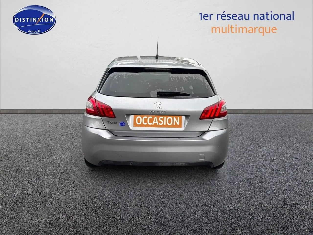 Vue arrière d'une Peugeot 308 gris Artense de 2019 avec feux rouges et plaque "OCCASION" visible.