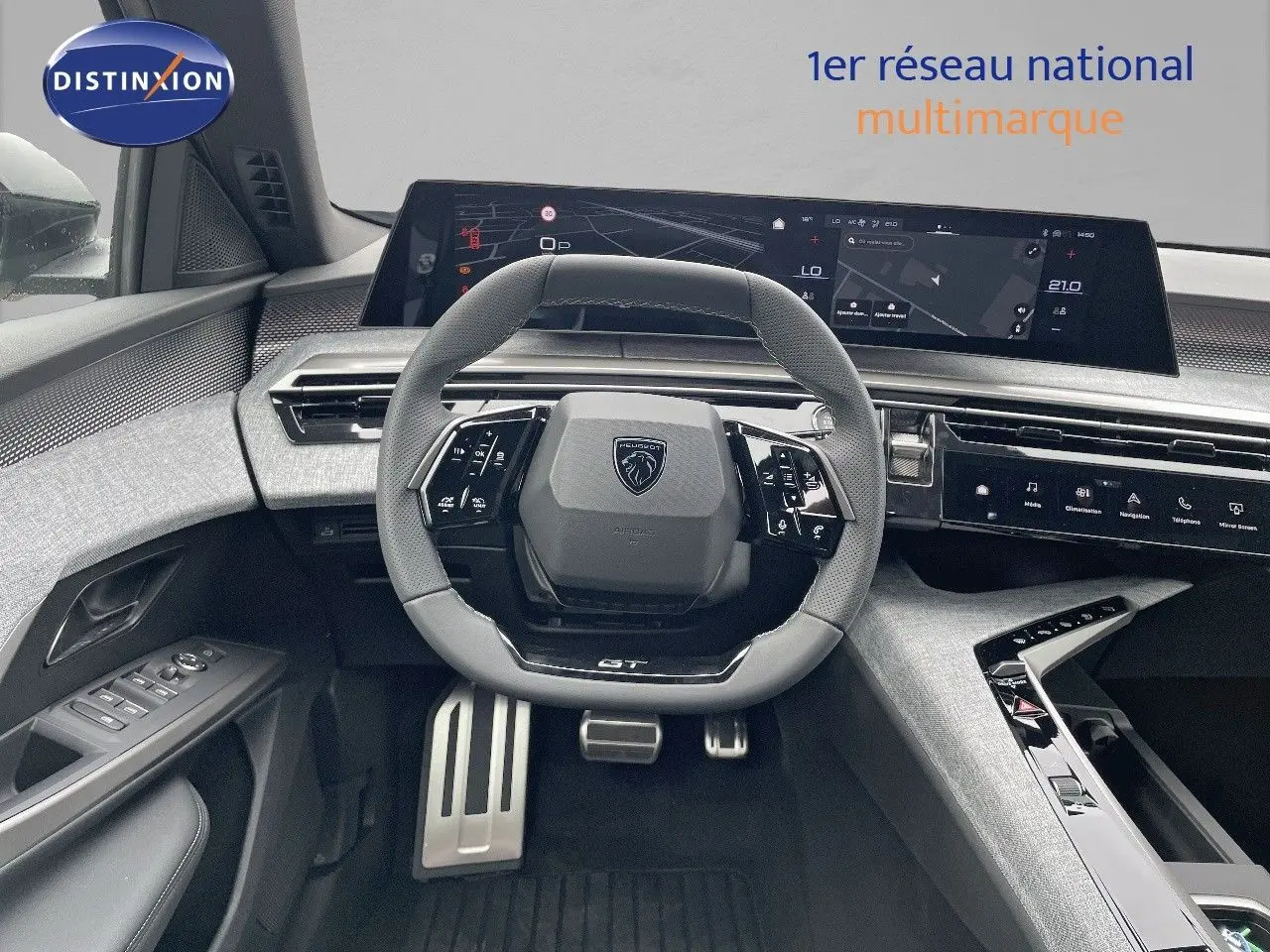 Intérieur du Peugeot 5008 Hybrid 2025, vue du poste de conduite avec volant GT et tableau de bord numérique large.