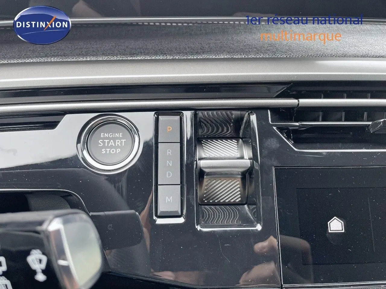 Gros plan sur la console centrale du Peugeot 5008 Hybrid 136ch GT 2025, avec bouton start/stop et commandes de boîte auto.