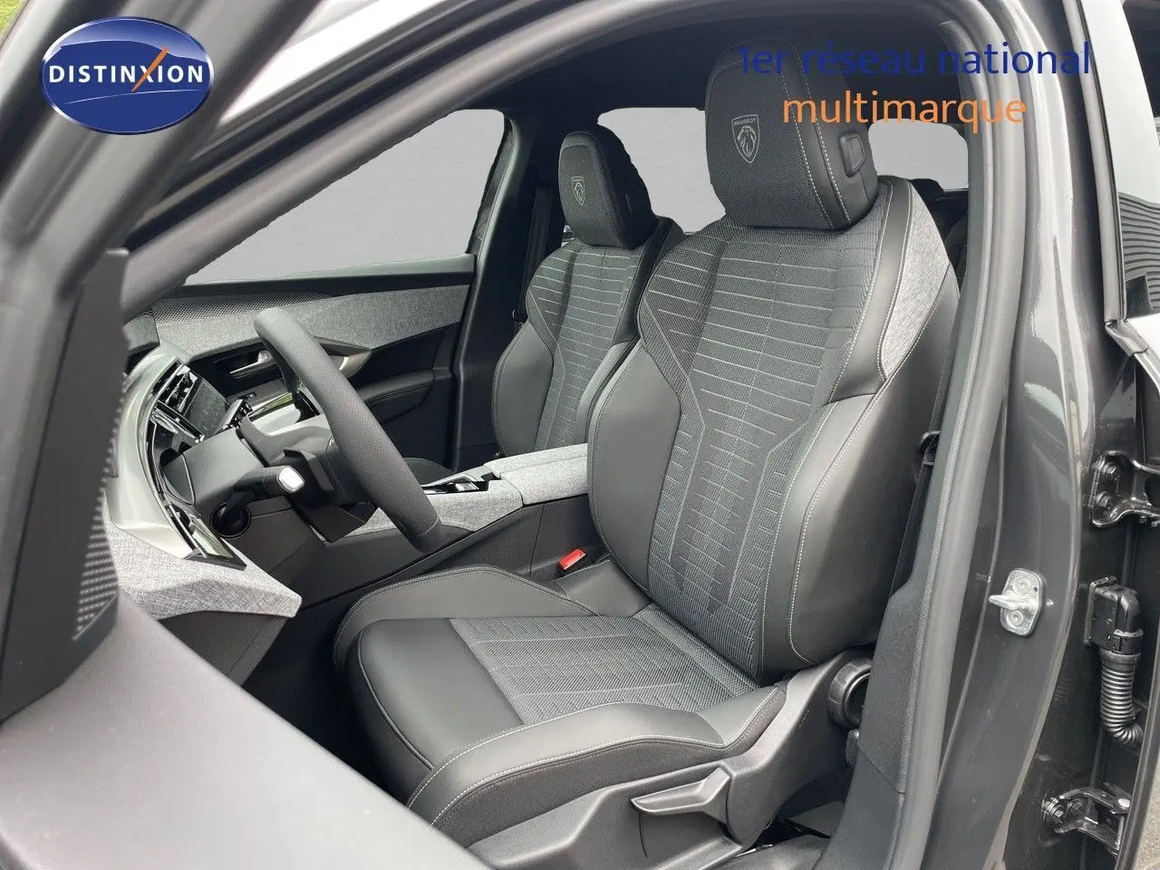 Vue intérieure côté conducteur du Peugeot 5008 gris titane, sièges en cuir noir et tissu gris avec logo Peugeot brodé.