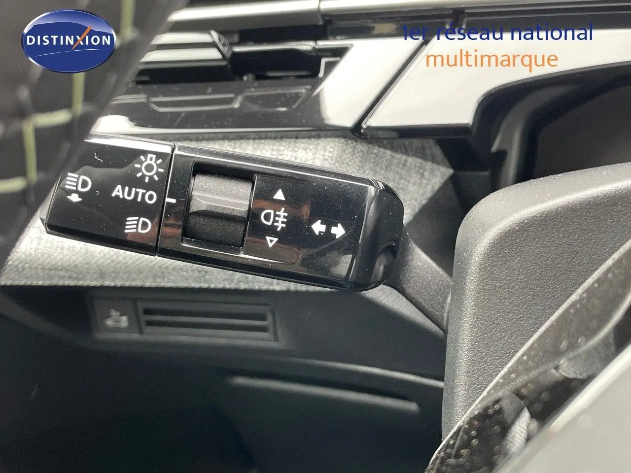 Gros plan sur la commande des phares et clignotants du Peugeot 5008 Hybrid gris titane, intérieur noir.