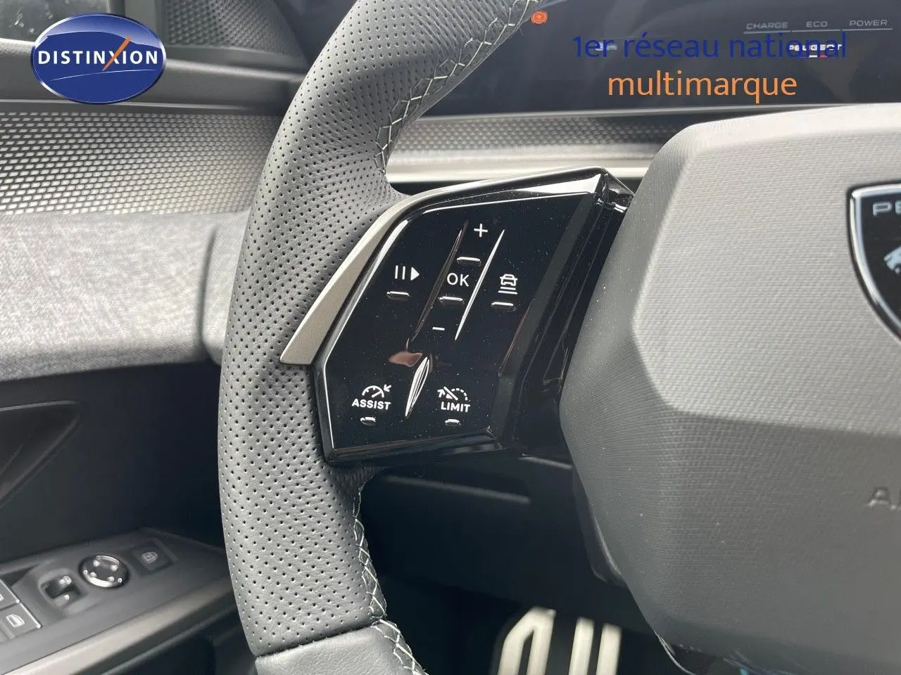 Gros plan sur le côté gauche du volant perforé du Peugeot 5008 Hybrid gris titane, avec commandes intégrées.