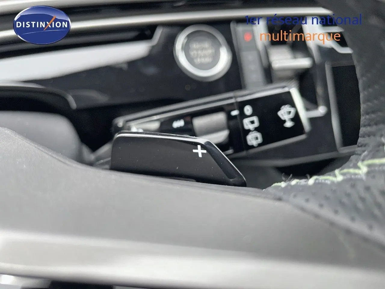 Gros plan sur la palette de changement de vitesse droite dans l'habitacle du Peugeot 5008 gris titane 2025 hybride.