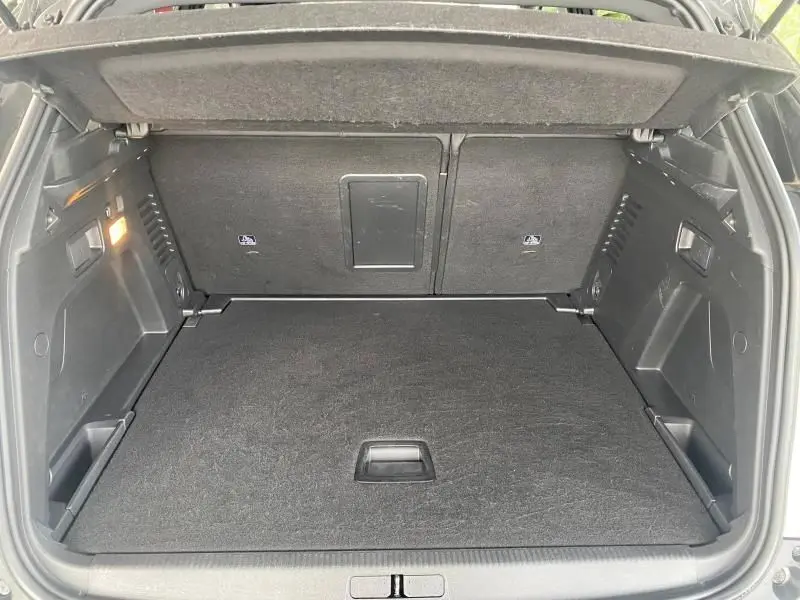 Coffre ouvert du Peugeot 3008 blanc nacré, vue de l'arrière montrant un espace de chargement propre et spacieux.