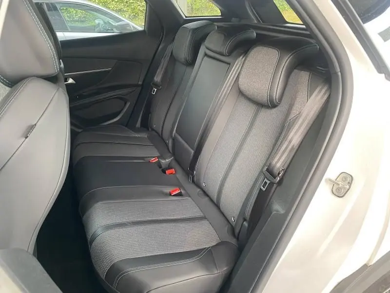 Vue côté droit de la banquette arrière en TEP et tissu gris du Peugeot 3008 blanc nacré 2023 avec ceintures et appuis-tête.