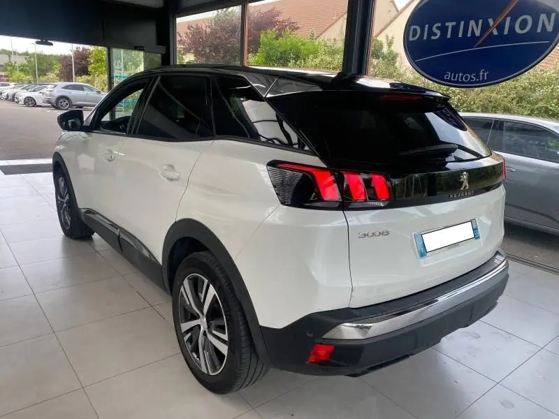 Vue 3/4 arrière droite d'un Peugeot 3008 blanc nacré avec toit noir et feux arrière LED distinctifs.