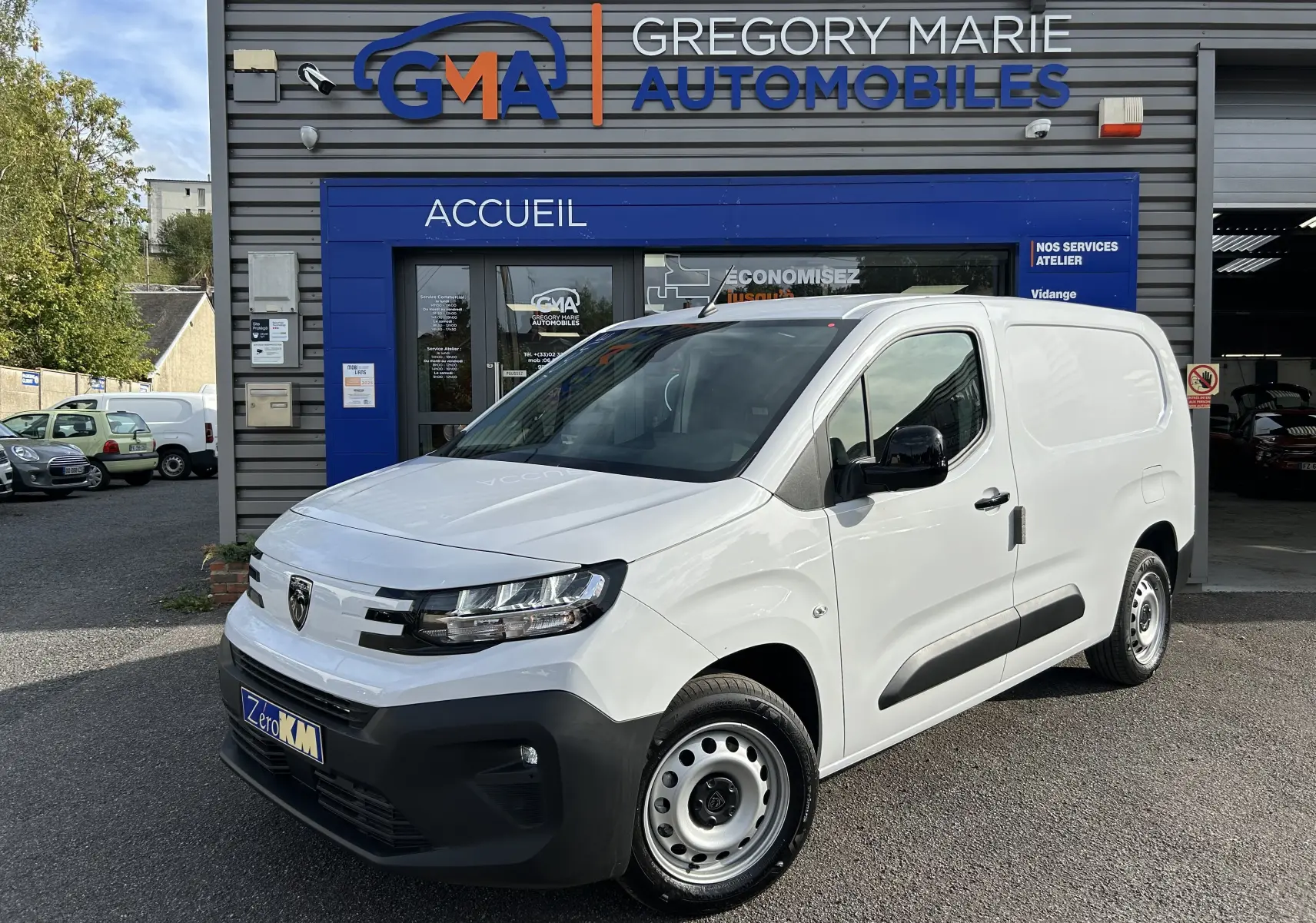 Peugeot Partner Fourgon blanc vu en 3/4 avant droit, avec rétroviseurs noirs et plancher bois visible à l'intérieur.