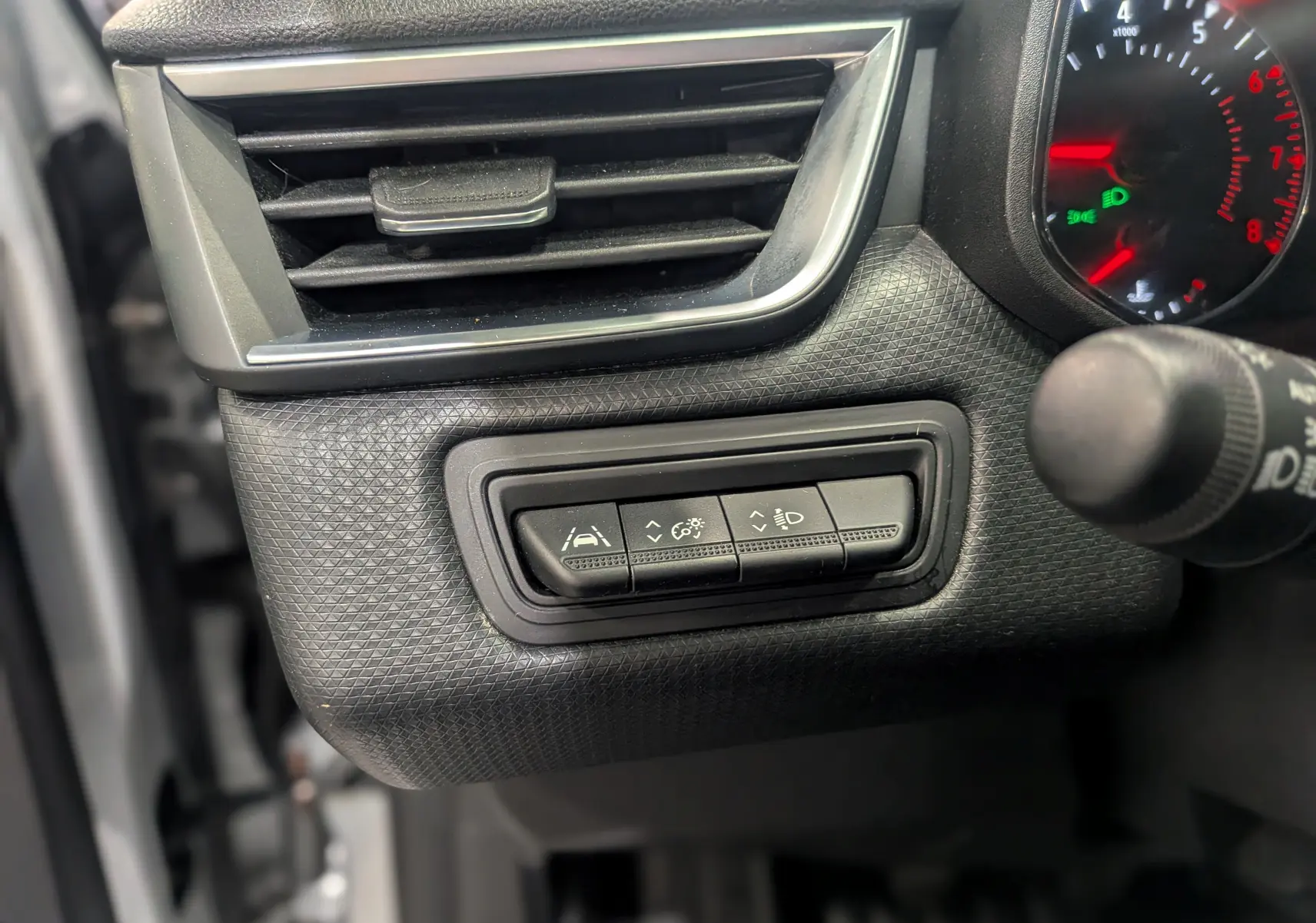 Détail intérieur côté gauche du tableau de bord gris platine de la Renault Clio V TCe 90 avec commandes d’assistance et ventilation.