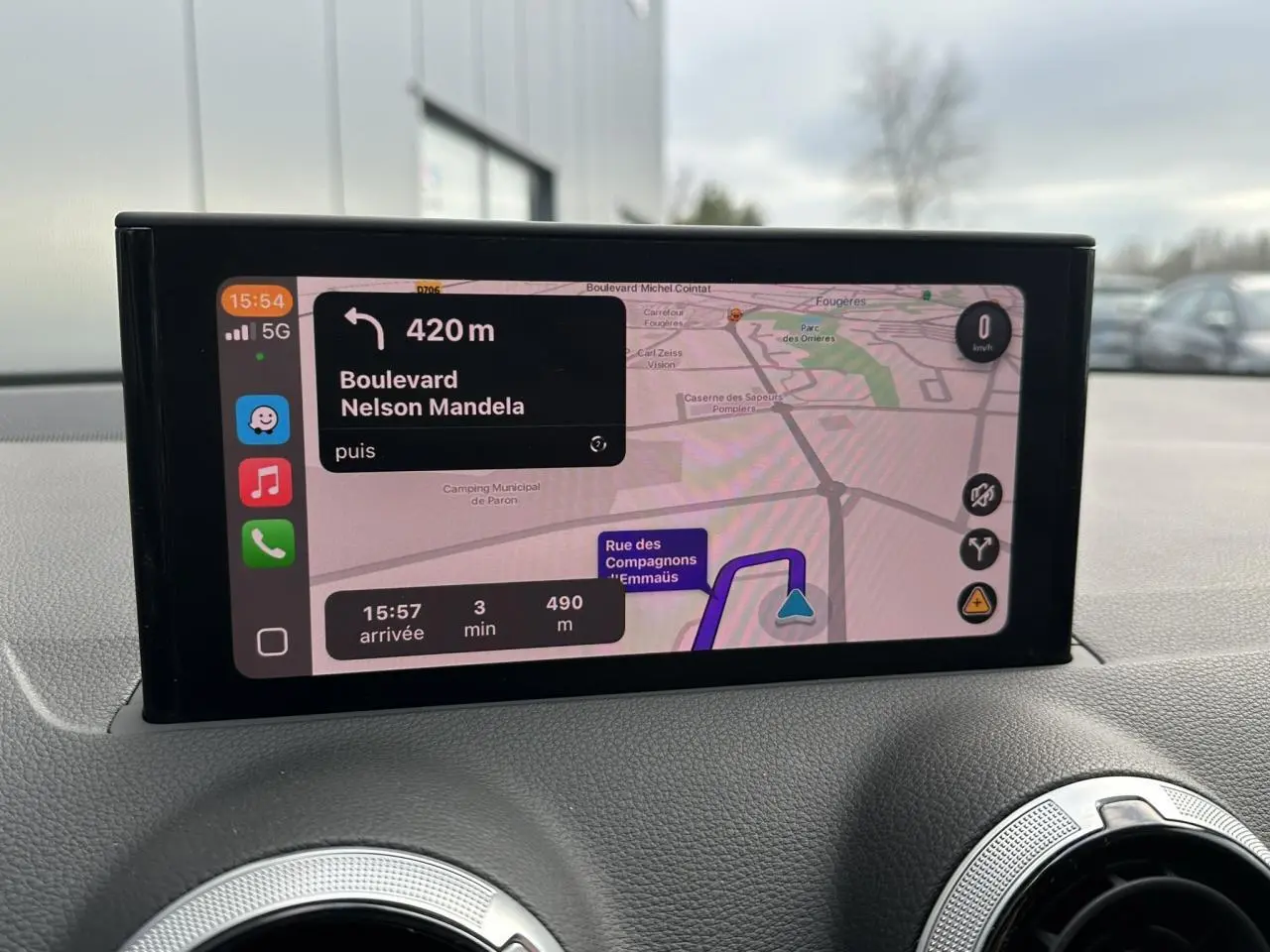 Vue intérieure du tableau de bord de l'Audi Q2 argent rosé, avec écran central affichant la navigation GPS.