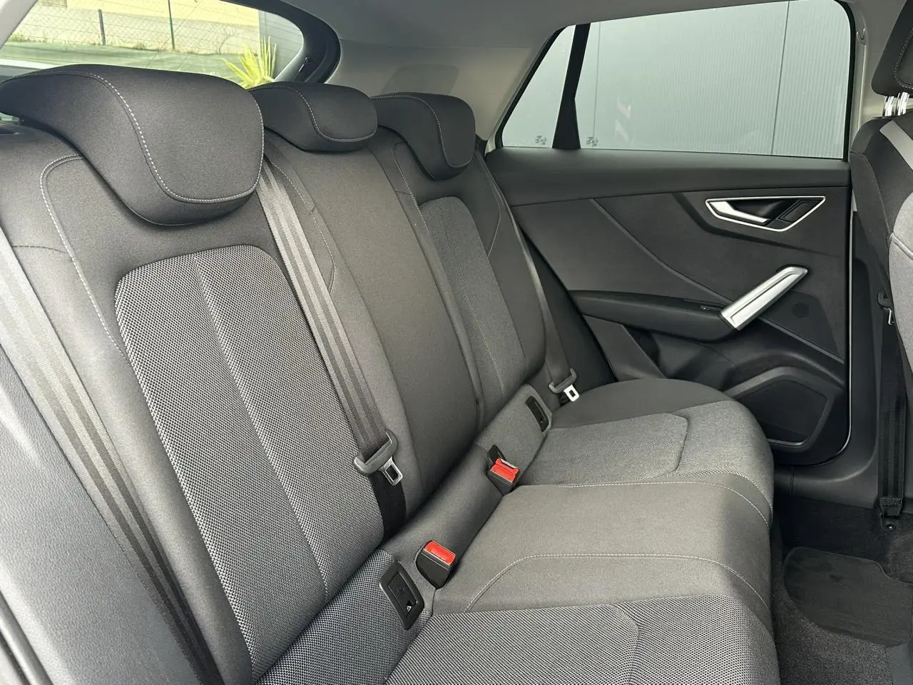 Vue intérieure côté droit des sièges arrière en tissu gris de l'Audi Q2 30 TFSI 110 S-Line 2024.
