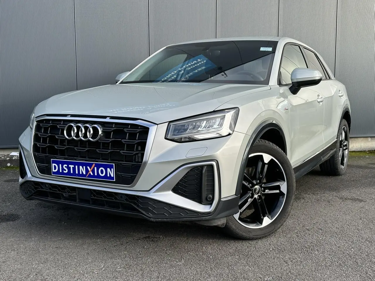 Audi Q2 30 TFSI S-Line argent rosé en 3/4 avant droit avec jantes noires et calandre noire distinctive.