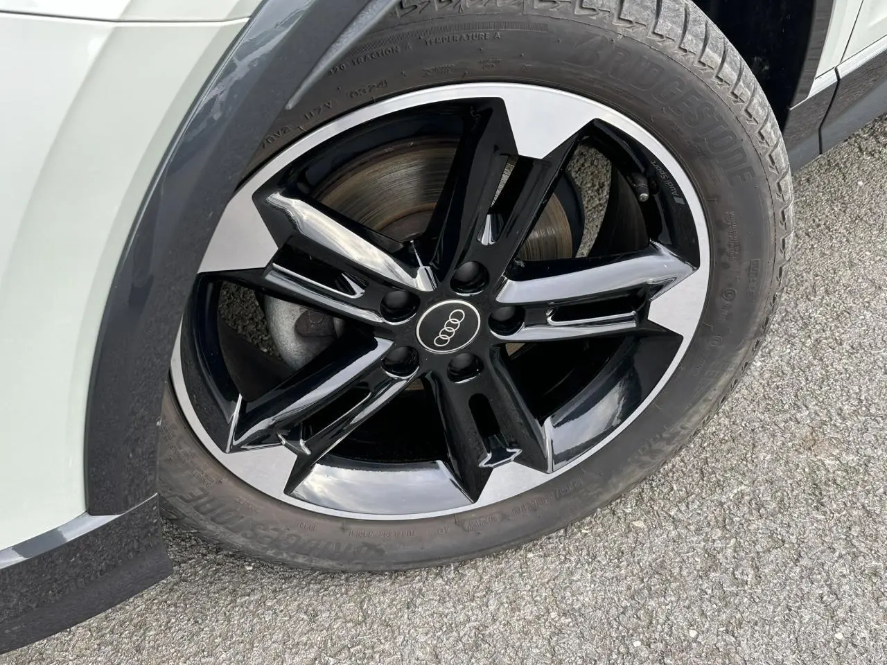 Gros plan sur la jante alliage noir et poli 7x18 à 5 branches doubles de l'Audi Q2 argent rosé, côté avant droit.