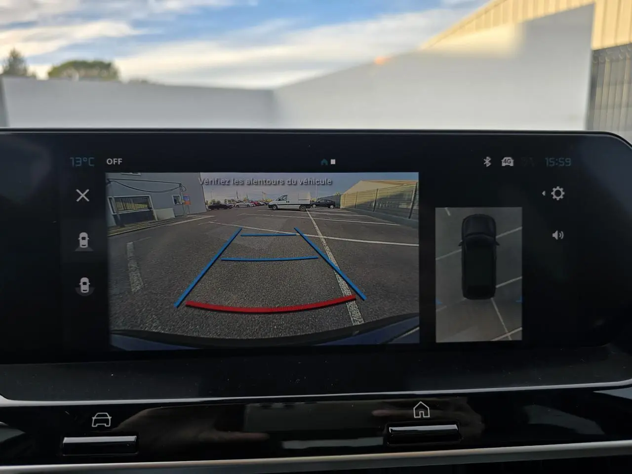 Affichage de la caméra de recul et vue 360° sur l'écran central du tableau de bord de la Citroën C4 bleu Eclipse toit noir.