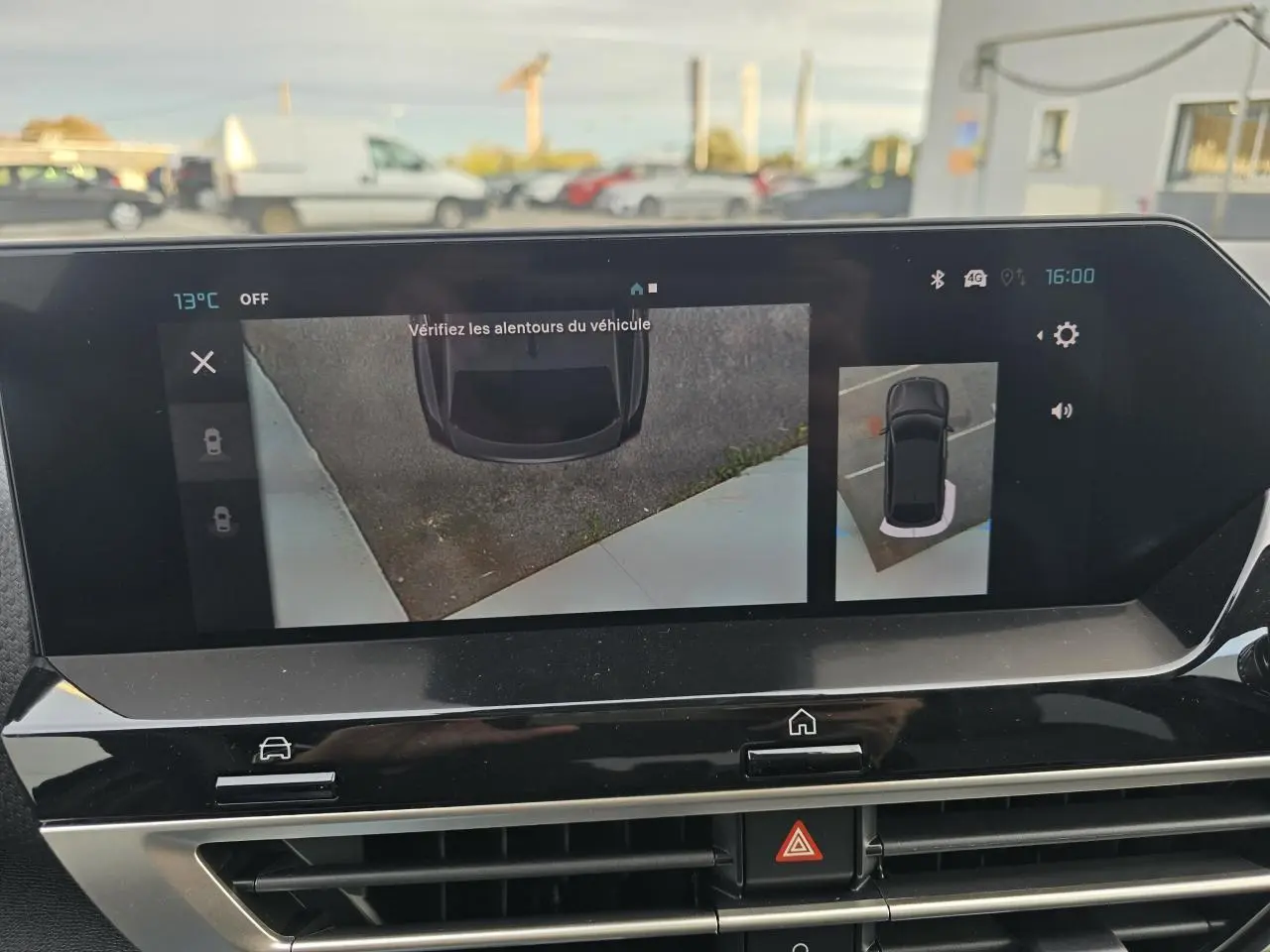 Écran central affichant la caméra de recul et la vue aérienne du Citroën C4 hybride bleu Eclipse avec toit noir.