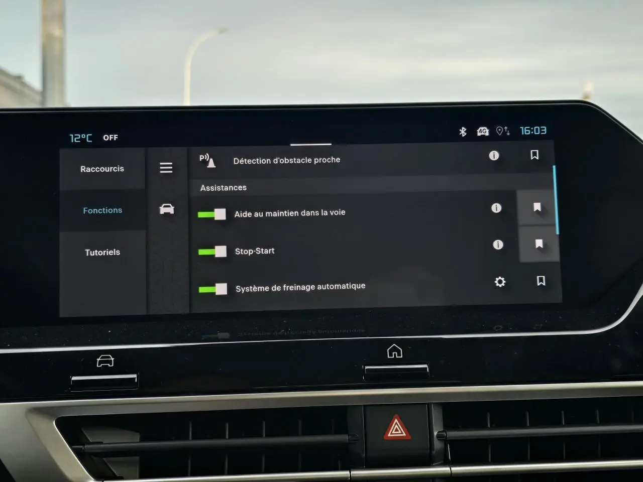 Écran tactile central du tableau de bord de la Citroën C4 hybride 2025 affichant les assistances à la conduite activées.