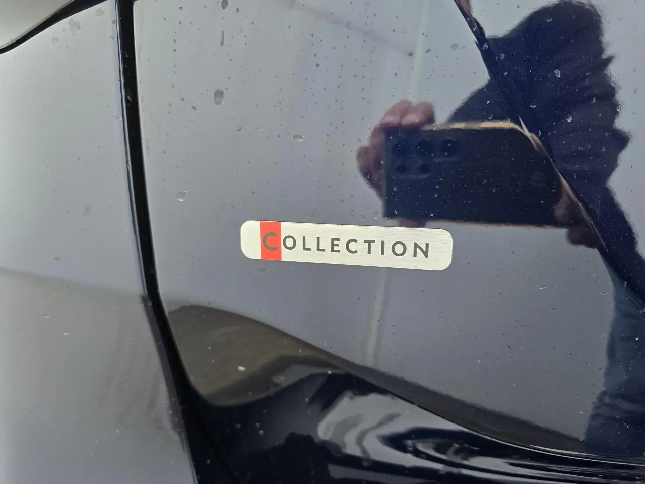Gros plan sur l'écusson "COLLECTION" sur la portière bleu eclipse d'une Citroën C4 III hybride 2025.
