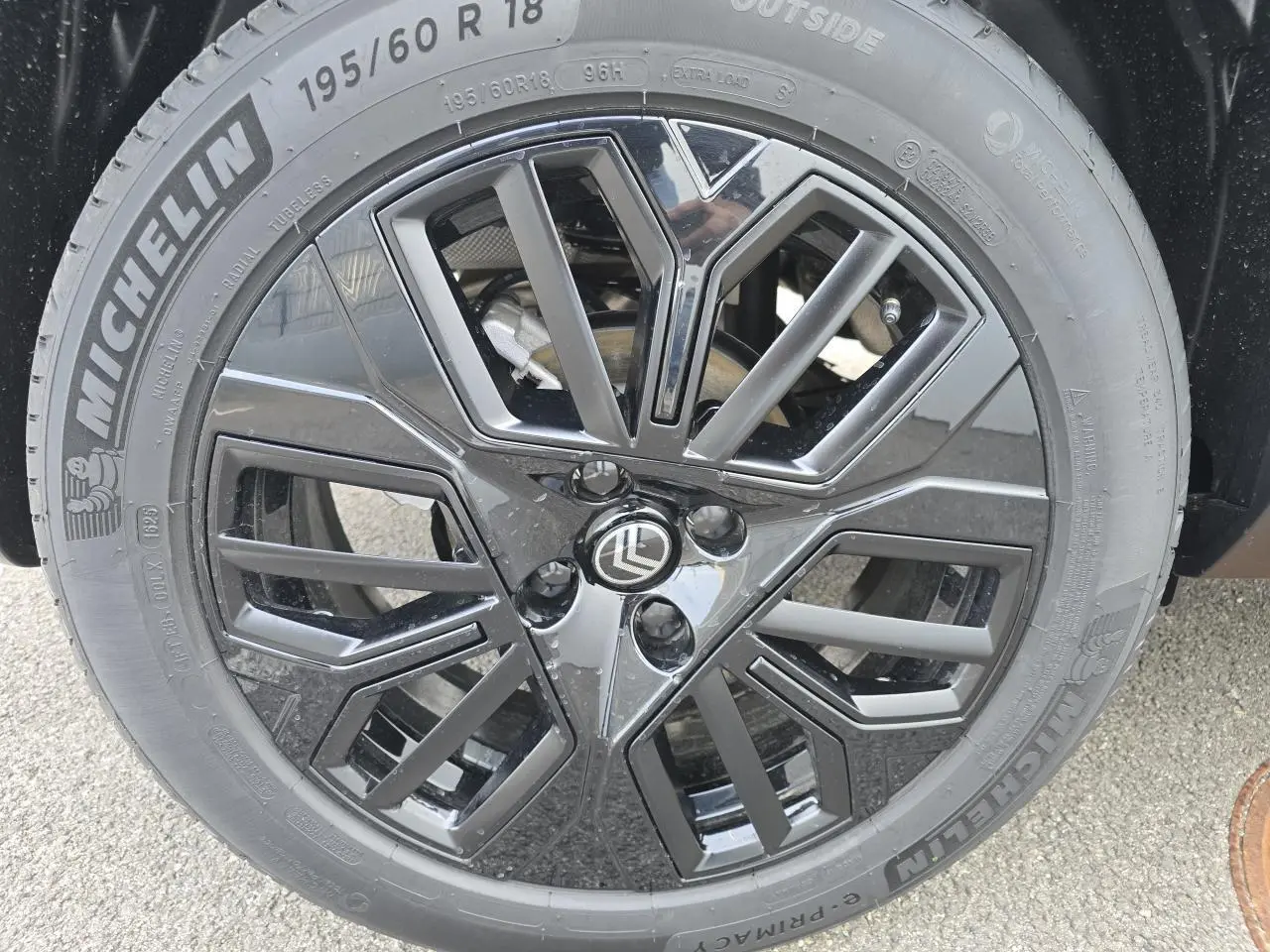 Gros plan sur la jante alliage noire 18 pouces Michelin d'une Citroën C4 bleu Eclipse avec toit noir