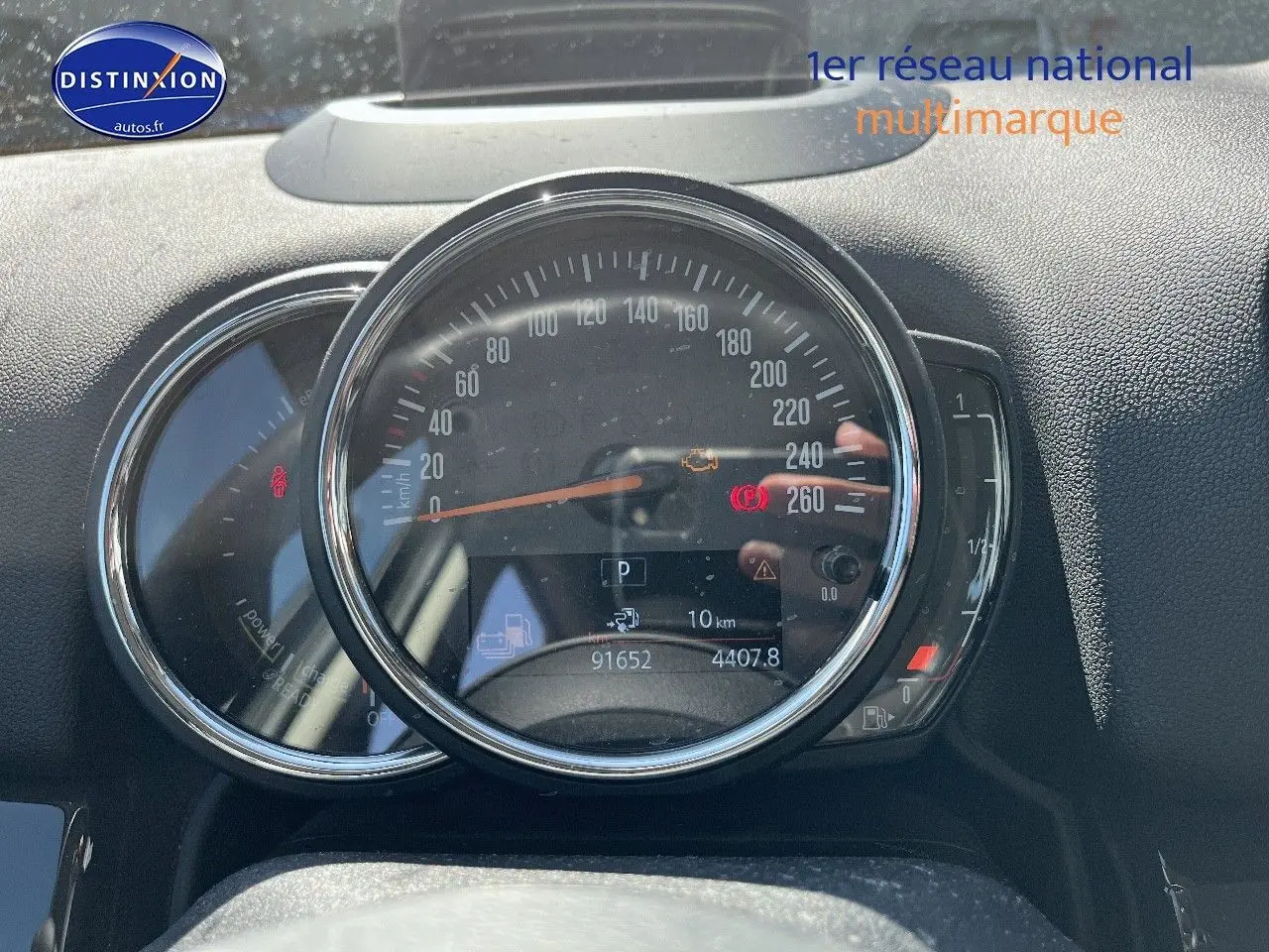 Vue rapprochée du combiné d'instruments du MINI Countryman gris, affichant le compteur de vitesse et les voyants allumés.