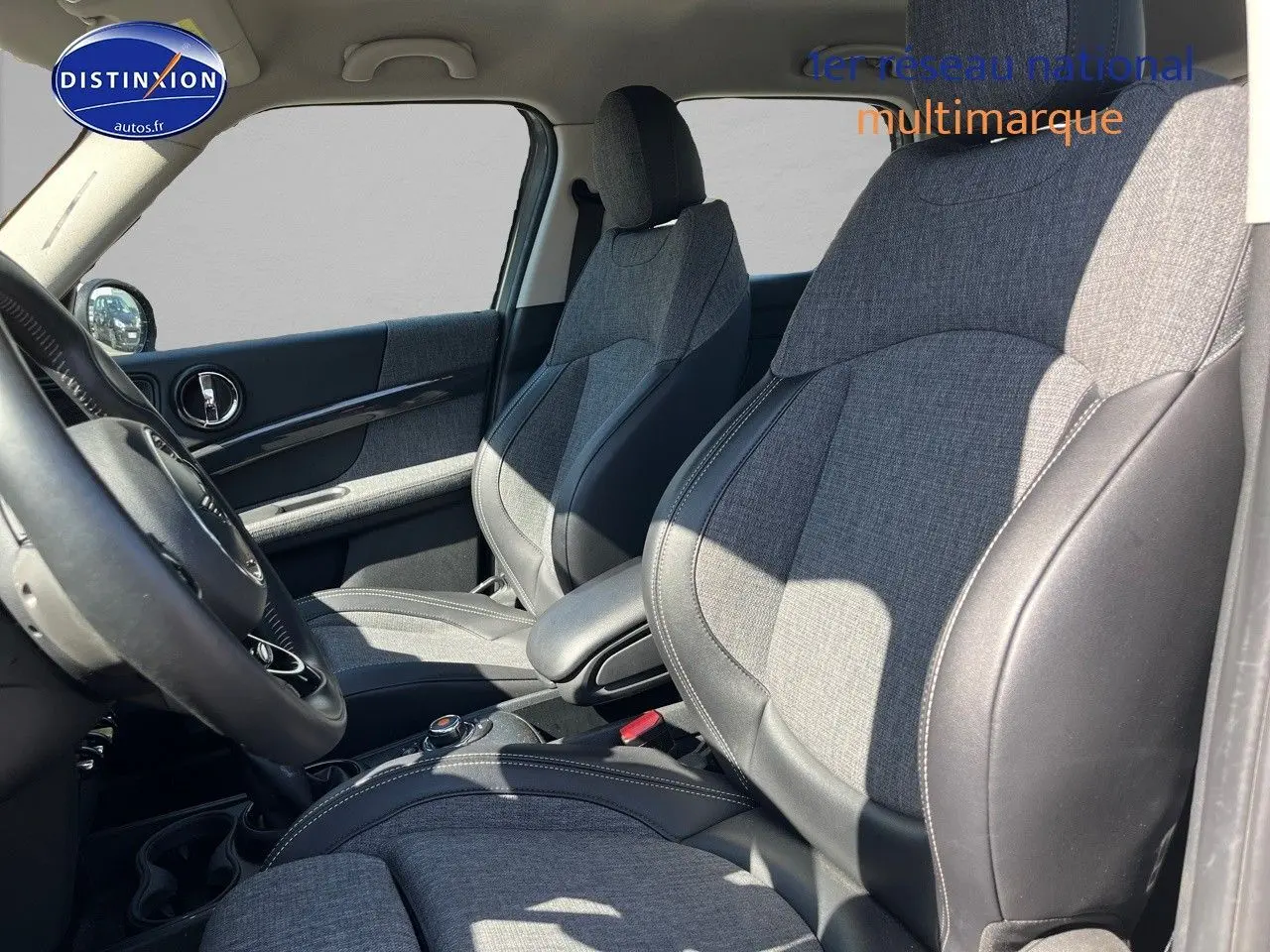 Vue intérieure côté conducteur du MINI Countryman Cooper SE avec sièges sport en tissu gris et cuir noir.