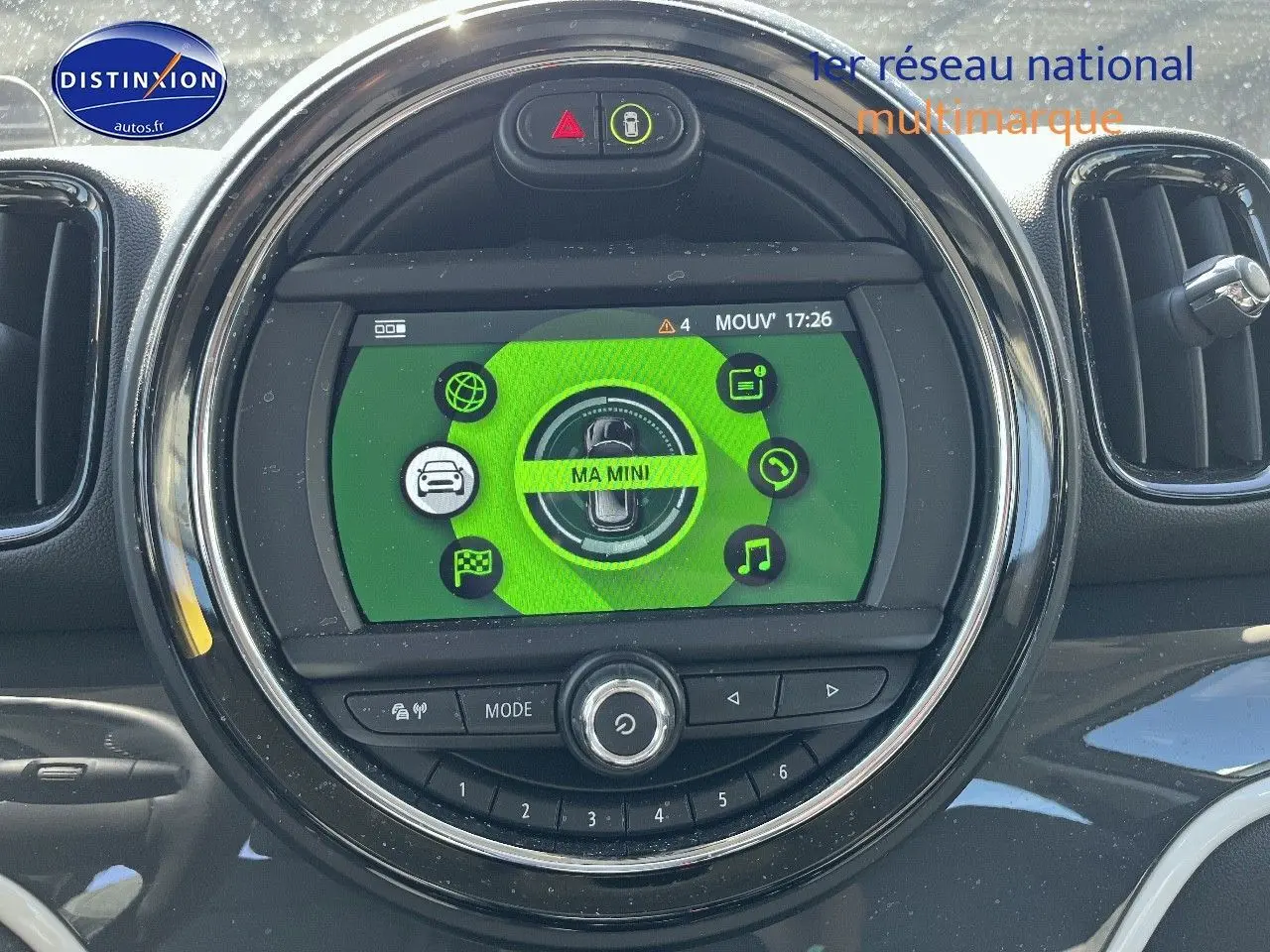 Écran multifonction circulaire du tableau de bord MINI Countryman avec interface verte et commandes intégrées.