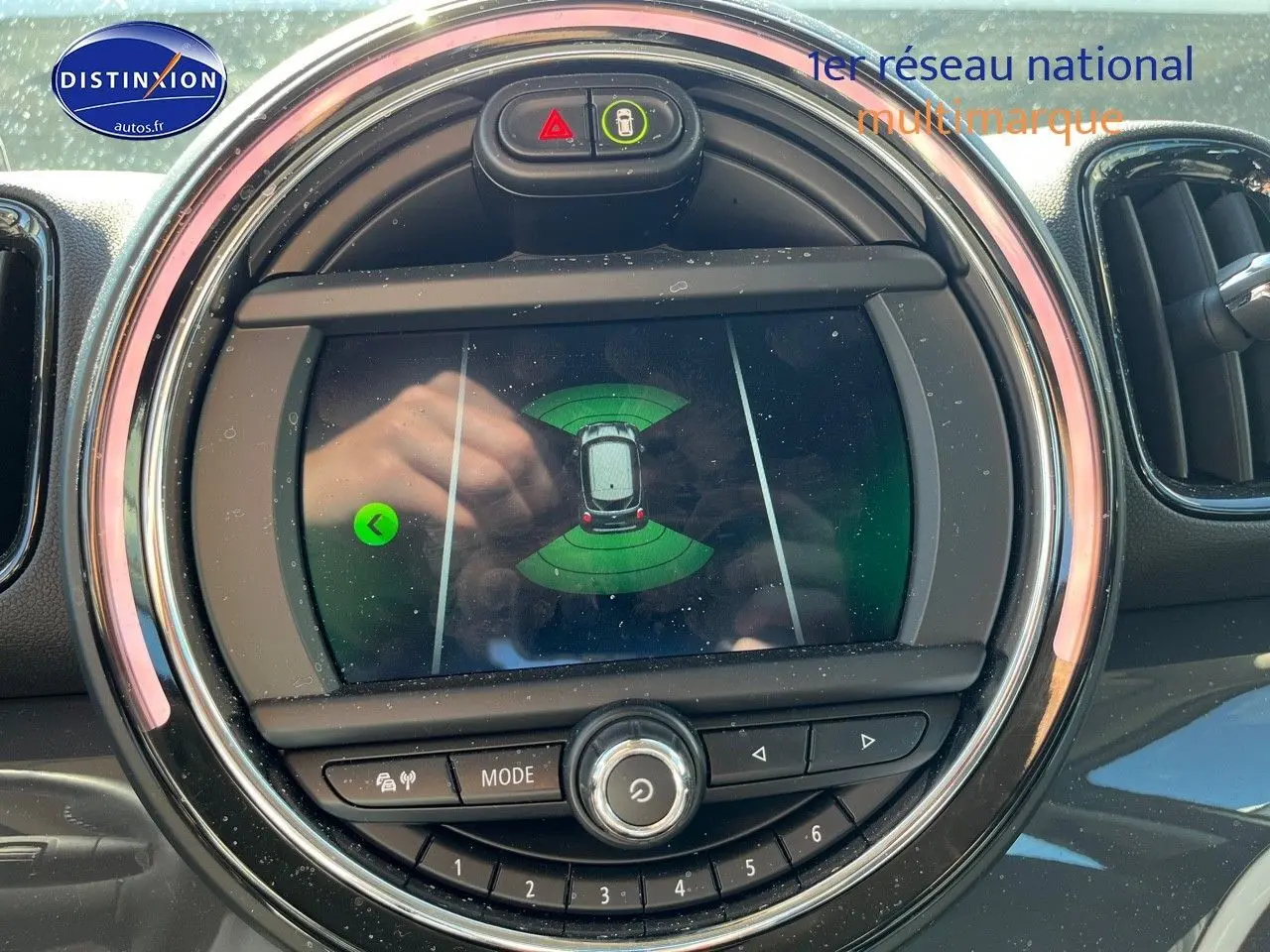 Affichage du système de stationnement sur l'écran central rond du tableau de bord d'une MINI Countryman Moonwalk Grey, vue intérieure.