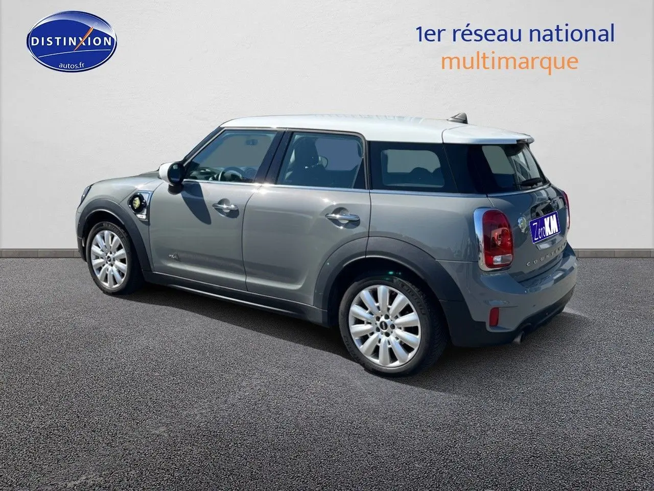 Vue 3/4 arrière droite d'une MINI Countryman hybride Moonwalk Grey avec toit blanc et jantes alu 18 pouces design Pin Spoke.