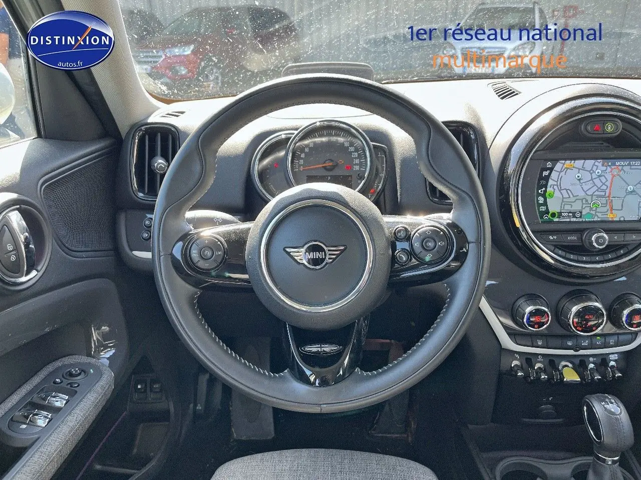 Vue intérieure centrée sur le volant cuir multifonction d'une MINI Countryman Moonwalk Grey avec écran GPS circulaire.