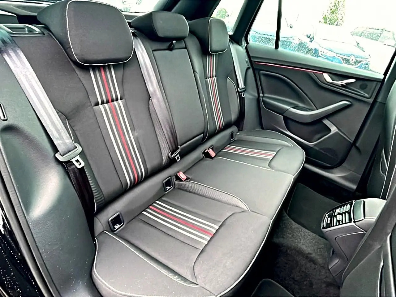 Vue côté droit de la banquette arrière noire avec bandes rouges et grises du Skoda Kamiq Monte Carlo 2026.