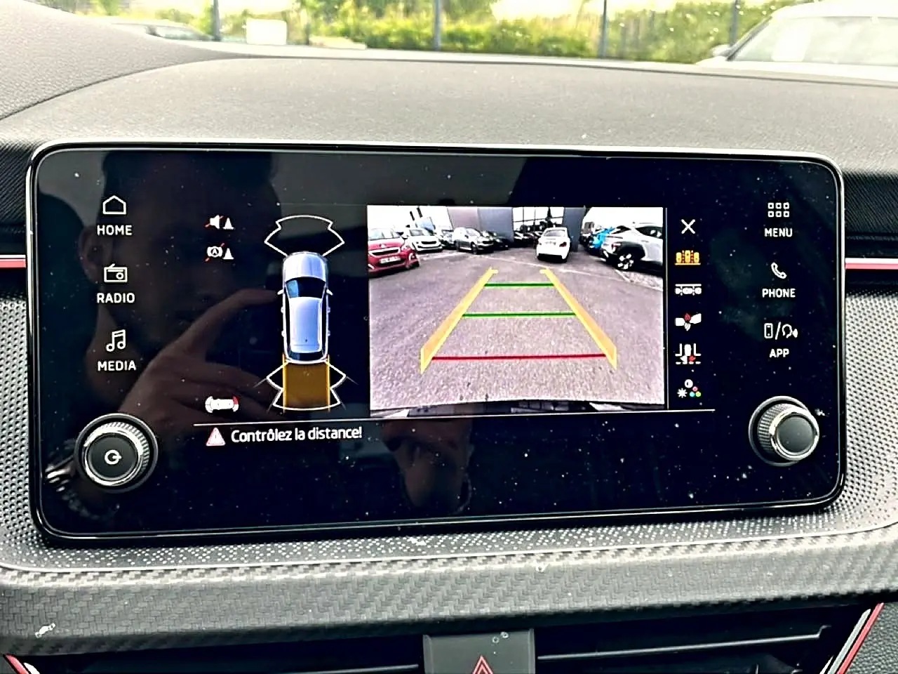 Écran tactile intérieur du Skoda Kamiq noir montrant la caméra de recul avec guidage de trajectoire coloré.