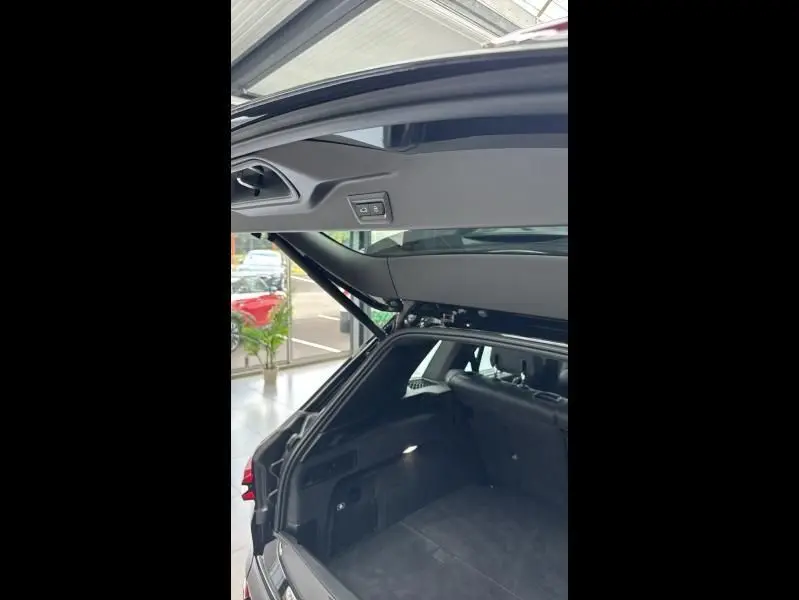 Vue arrière ouverte du coffre noir du BMW X5 xDrive50e 489ch M Sport 2023, intérieur spacieux et habillage sombre.
