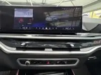 Tableau de bord moderne de BMW X5 xDrive50e noir 2023, avec écran tactile large et commandes intégrées élégantes.