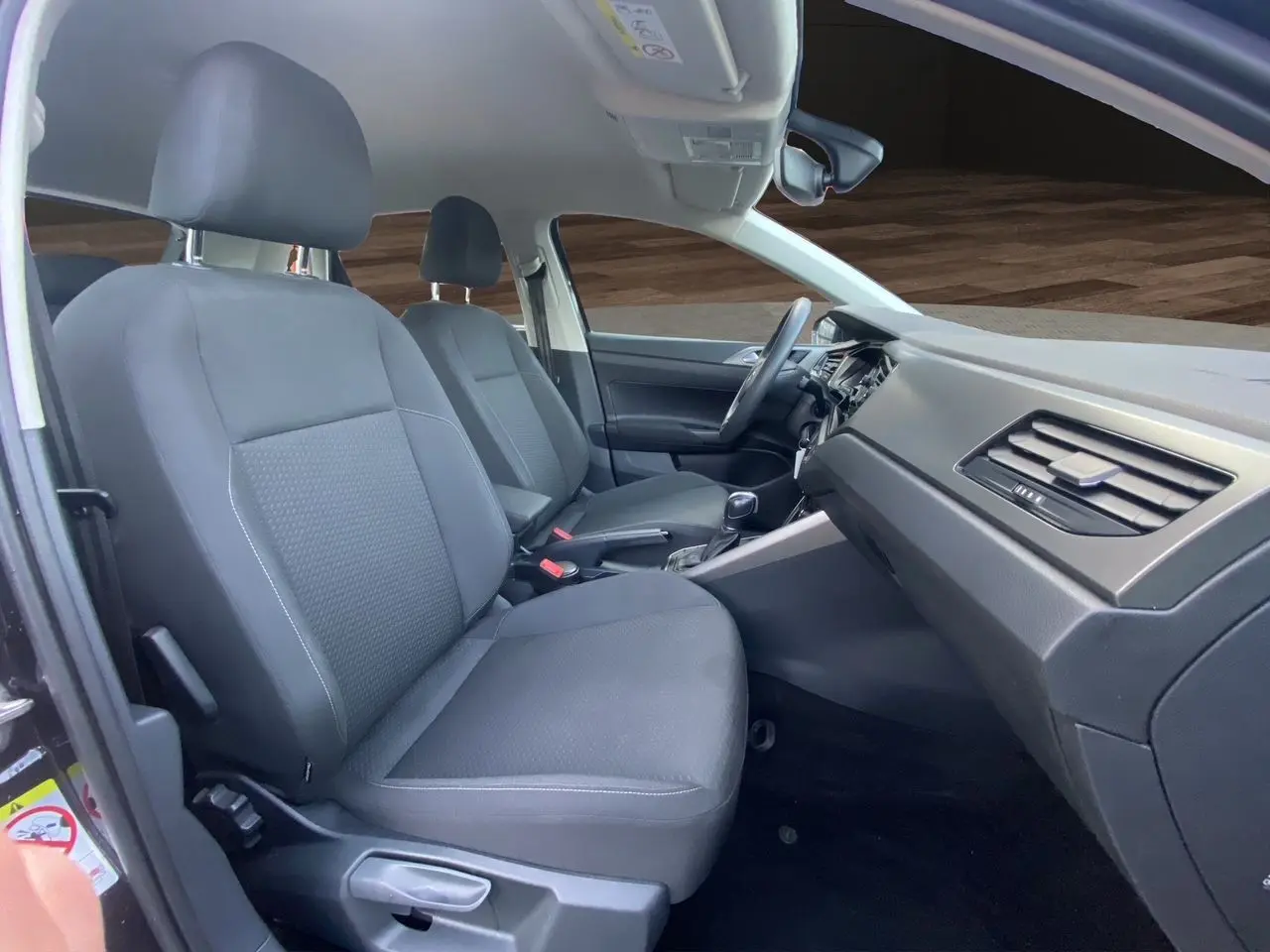 Intérieur noir de la Volkswagen Polo 2019, vue côté passager montrant sièges avant et tableau de bord.
