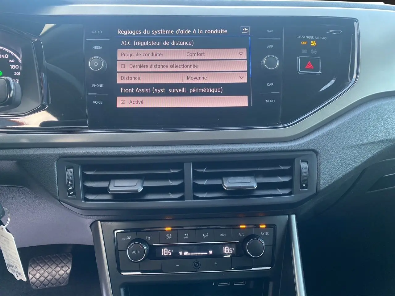 Vue rapprochée de la console centrale noire du Volkswagen Polo 2019, écran tactile affichant les réglages d'aide à la conduite.