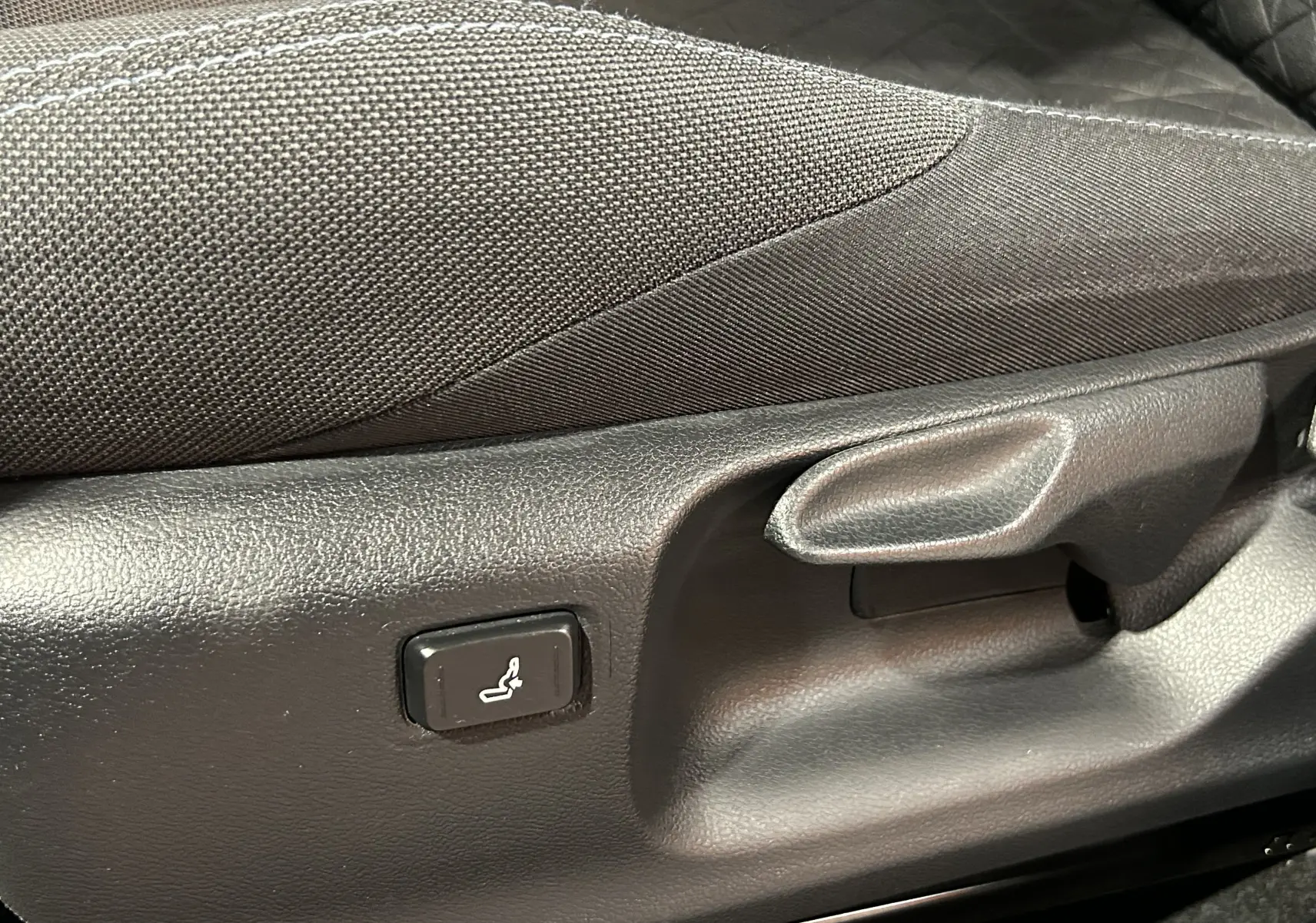 Détail de la commande de réglage de siège en tissu noir du Toyota C-HR Hybride 122h Edition 2WD vue côté gauche.