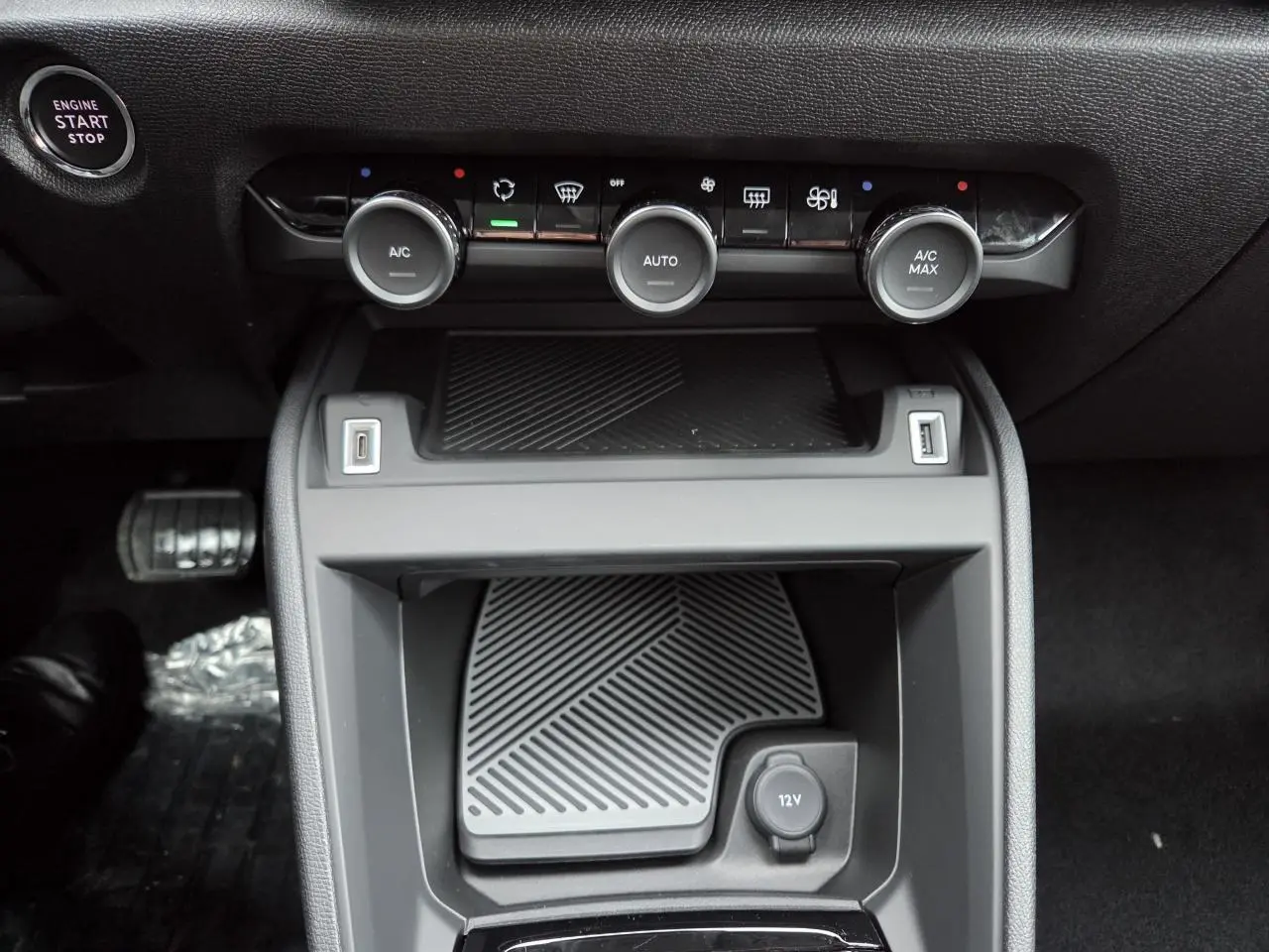 Vue rapprochée de la console centrale noire avec commandes climatisation et prise 12V de la Citroën C4 blanche toit noir
