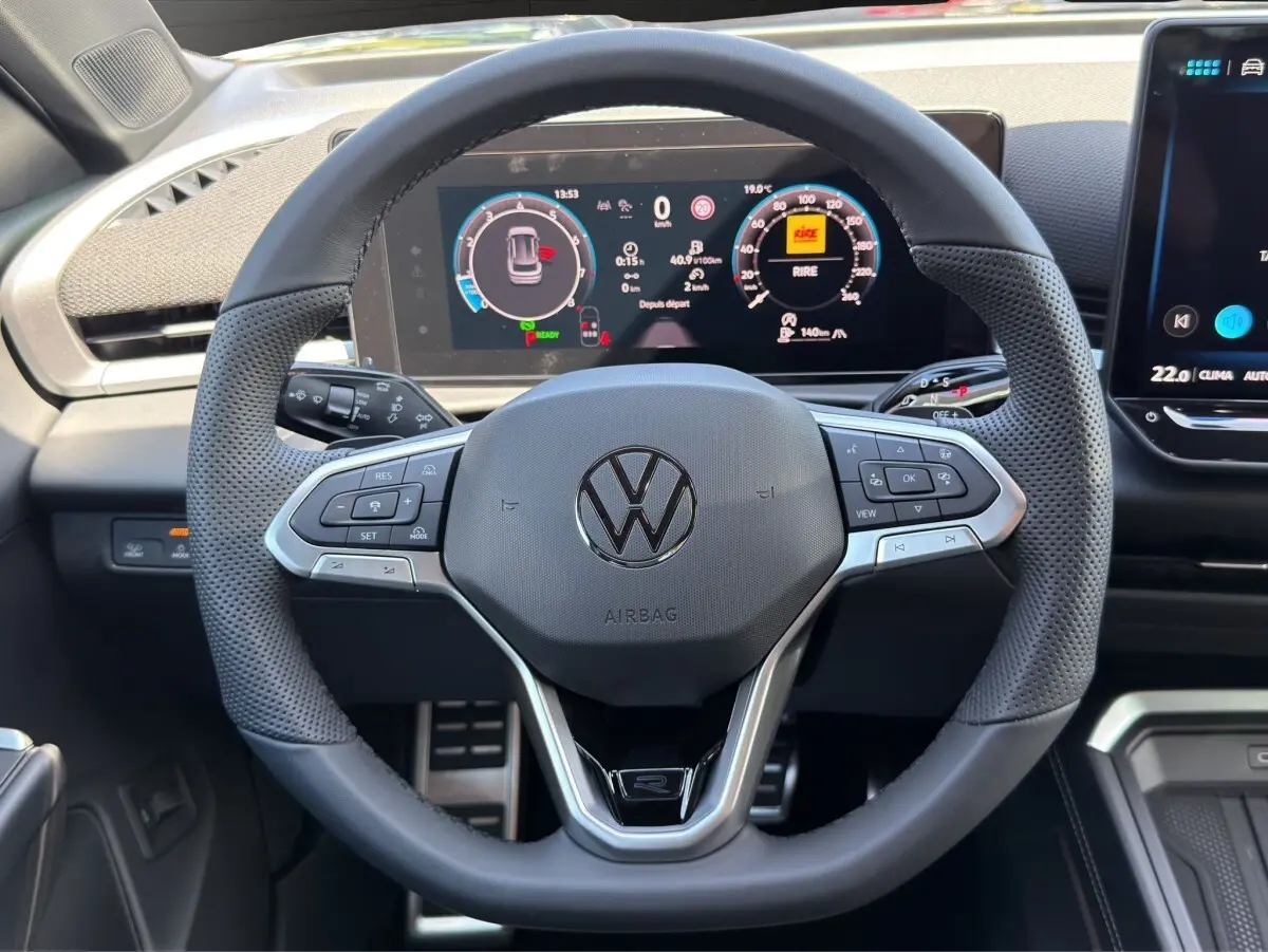 Vue rapprochée du volant cuir noir de Volkswagen T-Roc 2026 avec tableau de bord numérique et commandes multifonctions.