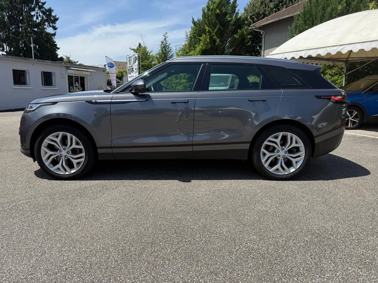 Profil côté gauche d'un Range Rover Velar gris 2019, mettant en valeur ses lignes épurées et ses jantes alliage.