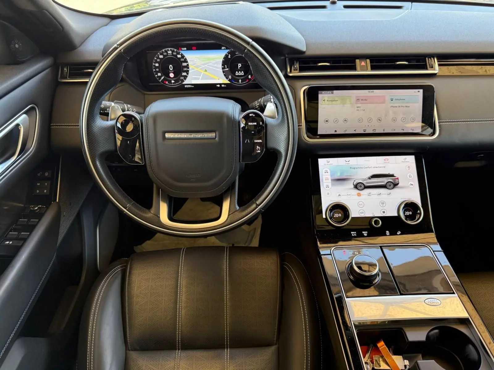 Vue intérieure du Range Rover Velar 2019 montrant le volant cuir, tableau de bord virtuel et double écran tactile central.