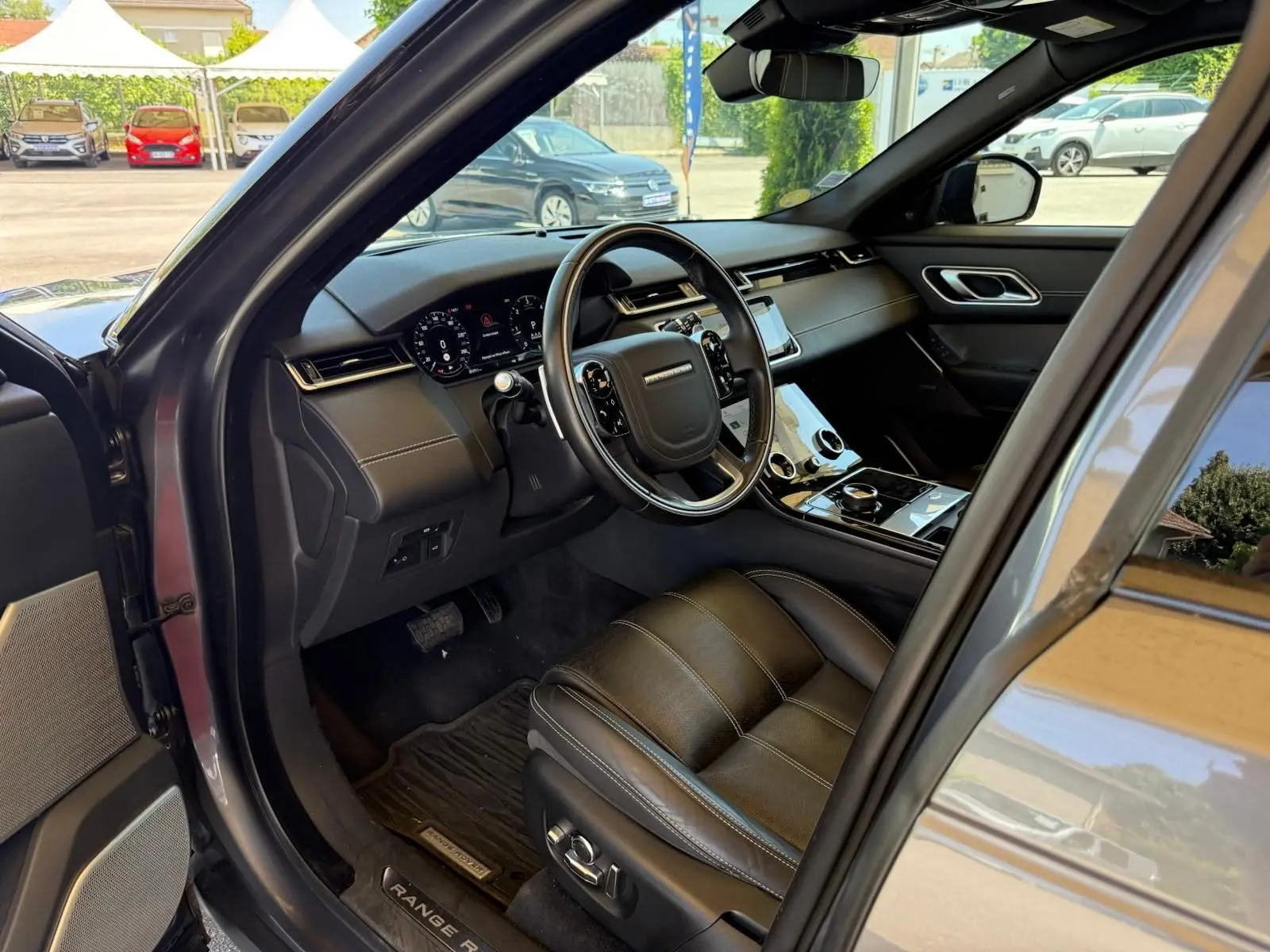 Intérieur côté conducteur du Range Rover Velar gris 2019, avec tableau de bord numérique et sellerie cuir Windsor.