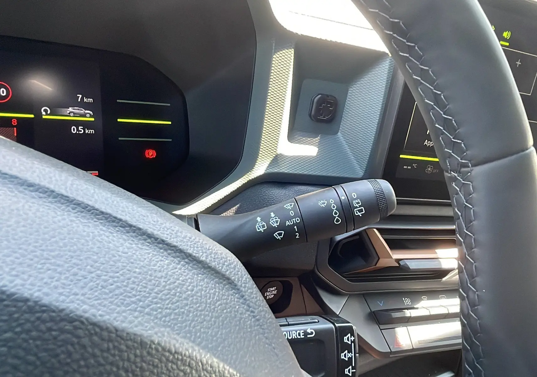 Intérieur du Dacia Duster 2025 blanc, vue rapprochée du tableau de bord et du volant avec commandes intégrées.