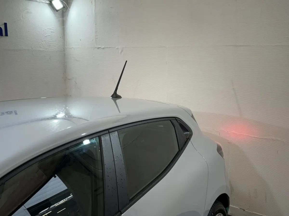 Vue arrière côté droit d'une Renault Clio gris clair 2025 avec antenne sur le toit et vitre teintée.